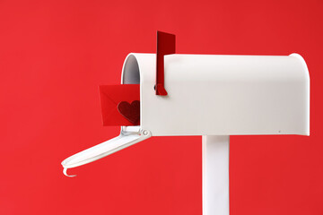 Mailbox with letter and paper heart on red background. Valentine's Day celebration