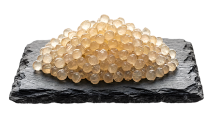Pile of luxury white caviar or snail caviar pearls on a black slate stone plate