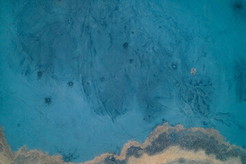 Abstract blue ice texture of frozen lake surface with frost patterns and bubbles, cold winter nature background, top down aerial drone shot © UrbanWitness