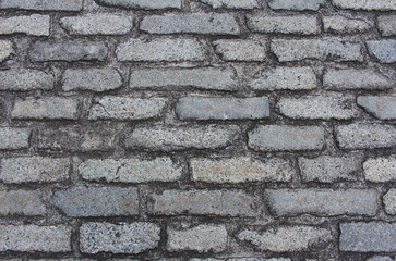 Texture of cobblestone. Pattern of sidewalk tiles in the street. Cobblestones close up background.