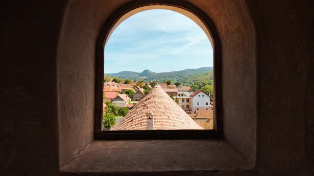 Sukosd-Bethlen Castle, Racos, Brasov, Romania, fortified walls and corner towers in rugged stone overlooking fields and the village