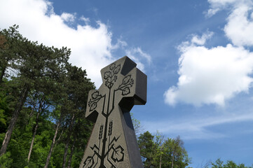 Stone cross with carved ornament against blue sky