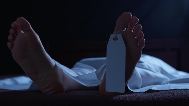 A human corpse lying in a morgue, covered with a white sheet and a tag on its leg. Concept of a dead person, a deceased person.