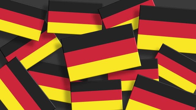 Pile of German flags scattered randomly on dark gray background