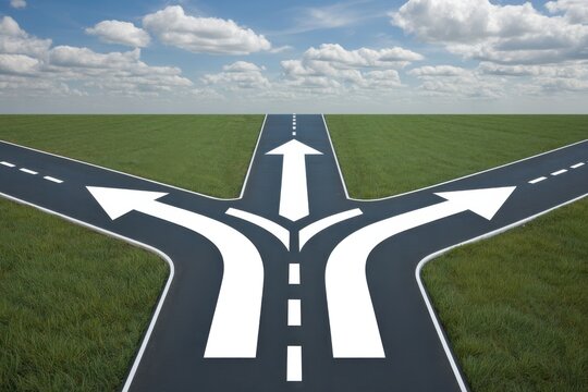 Asphalt road splits into three directions with white arrows in green field intersection