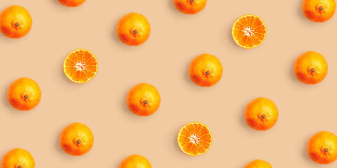 Tangerine pattern on beige background. Minimalist repeat composition with fresh whole and sliced mandarins