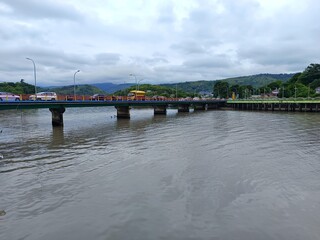 River bridge with vehicles and green hills