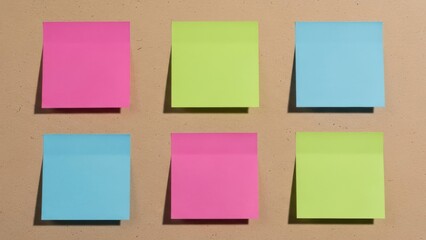 Pink, green, and blue sticky notes on a corkboard background
