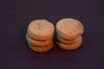 Two Stacks of Sandwich Cookies on Dark Wooden Table, Simple Snack Scene for Home Kitchen.