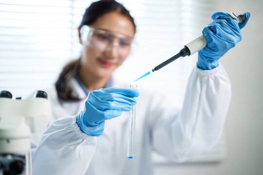 Asian adult woman scientist conducts laboratory research using pipette test tube developing new science medicine technology in sterile lab environment