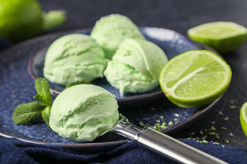 Plates with lime ice cream, mint leaves and metal scoop, closeup