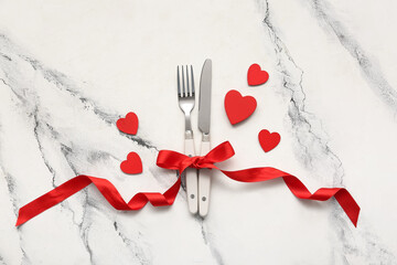Composition with cutlery, ribbon and decorative hearts on marble background. Valentine's Day...