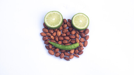 Smiling Face Made of Peanuts With Lime Slices and Green Chili.