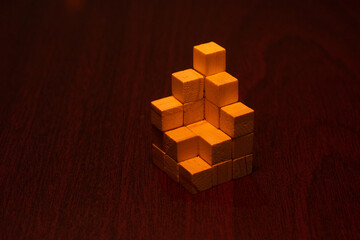 Wooden Cubes Stacked on a Dark Wood Surface. Creative Structure.