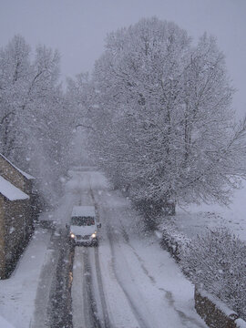 Fourgonnette blanche circulant sur une route enneig&eacute;e en campagne, S&eacute;v&eacute;rac-l'Eglise, Aveyron, Occitanie, France