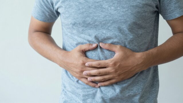 Man suffering from intolerance or food poisoning, stomach ache, abdominal pain, colon problems, gastritis, diarrhea or inflammation. Patient's hand on the belly or abdomen.	