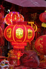 Fototapeta premium Vibrant red Chinese lanterns with gold Chinese characters illuminate a festive market stall