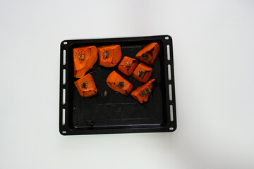 Delicious traditional roasted pumpkin slices topped with walnuts. Sustainable and natural dessert background featuring copy space for mindfulness, balance and herbal nutrition themes.