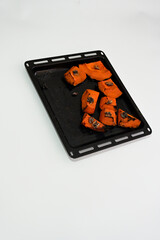 Baked pumpkin dessert with walnuts in oven tray on white background, organic natural sweet with botanical ingredients for wellness and harmony, eco friendly healthy food concept.