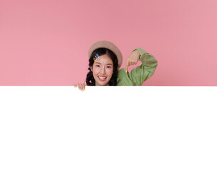 Promotional banner advertising concept with Asian woman pointing at blank white space while smiling to present marketing message call to action copy space for online campaign.