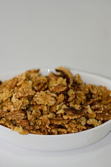 Bowl of cracked walnut kernels on white background, organic natural superfood for wellness and brain health, botanical plant based nutrition for mindfulness and balance, copy space.