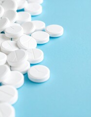 Close-up of round white tablets scattered on a blue background .