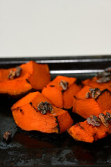 Delicious traditional roasted pumpkin slices topped with walnuts. Sustainable and natural dessert background featuring copy space for mindfulness, balance and herbal nutrition themes.