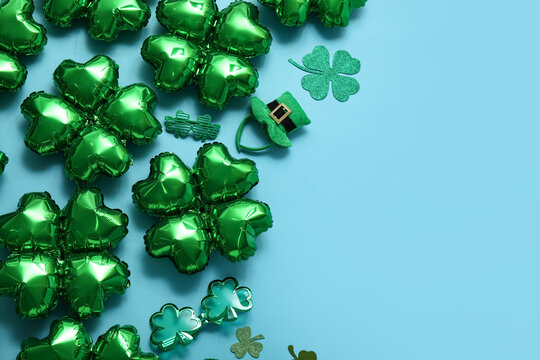 Balloons in shape of clover and decorations for St. Patrick's Day celebration on blue background - Powered by Adobe