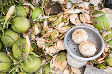 Fresh green coconuts and coconut shells at Asian street market stall