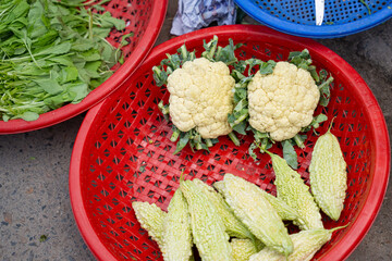 Fresh vegetables in plastic baskets at local Asian street market outdoor