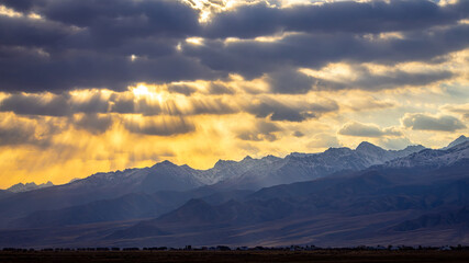 Sun rays coming through dark clouds into landscape