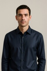 Fototapeta premium Young businessman standing in a minimalist setting, embodying a corporate executive or professional look