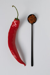 Homemade spicy chili sauce with peppers in black teaspoon