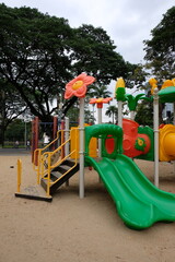 Vibrant playground with slides and climbing structures set against a backdrop of trees