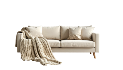 A neutral-toned sofa with pillows and a cozy blanket, against a black backdrop