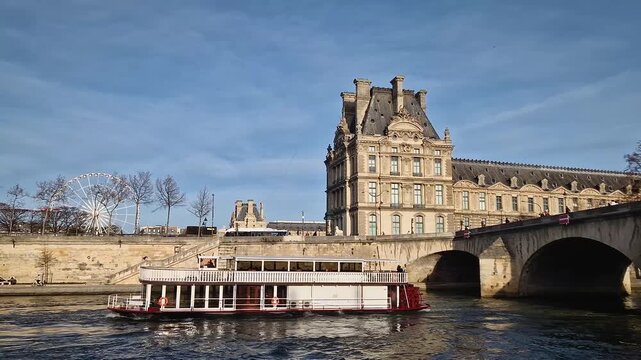 Paris, France - December 10, 2025: View from a cruising boat along the Seine River to the historic Pont Royal bridge, the ornate facade of the Louvre Museum and Grande Roue de Paris Ferris wheel