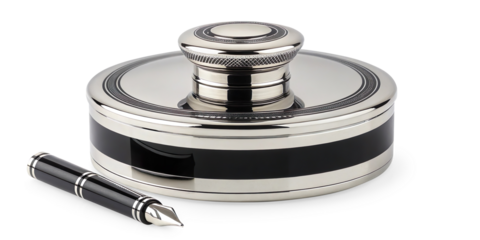 A polished, luxury writing set featuring an ornate silver inkwell with a black band detail, accompanied by a matching black and silver fountain pen resting beside it on a transparent background.