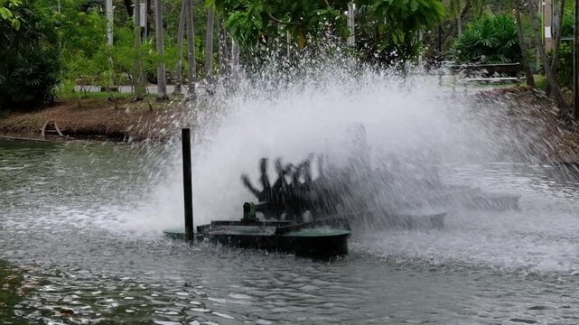 Water aerator machine creating splashes and oxygenating a pond in a lush green environment
