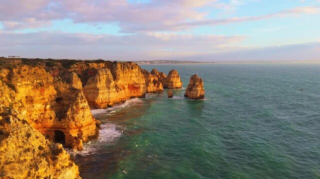 Ponta da Piedade Rock Formations, Golden Cliffs and Atlantic Ocean on Sunny Morning. Aerial View. Lagos, Algarve, Portugal. Moving Backwards