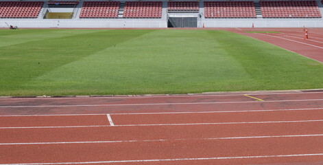 Fototapeta premium Outdoor sports stadium with a red running track with white lane markings