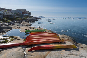 Vibrant Kayaks Lined Up on the Arctic Coastline in Summer © Michel