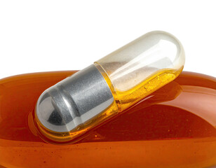 A clear, silver-capped gel capsule filled with golden liquid, resting on a dark amber surface