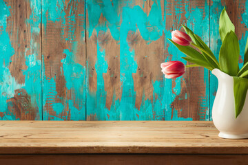 Empty wooden table with spring tulip flower bouquet over rustic background