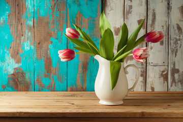 Spring tulip flower bouquet on wooden table over rustic background