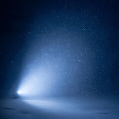 Snowstorm light beam illuminating dark winter landscape  