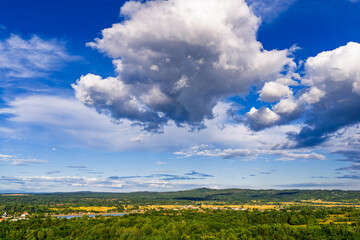 Scenic view of Tismana village in Gorj County Romania under a bright blue sky with fluffy clouds. A stunning landscape captures the beauty of Tismana village in Gorj County. Tismana, Romania.