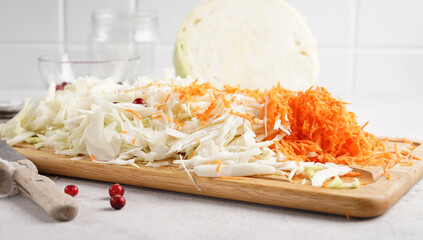 Pickling cabbage with carrot at home on table. Prepare homemade sauerkraut or fermented cabbage with carrot. selective focus