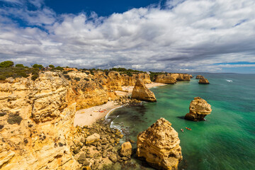 Praia da Marinha, beautiful beach Marinha in Algarve, Portugal. Navy Beach (Praia da Marinha) with flying seagulls over the beach, located on the Atlantic coast in Lagoa Municipality, Algarve.