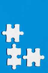 Fototapeta premium White jigsaw puzzle pieces. Fill in pieces of the jigsaw puzzle. Complete the jigsaw puzzle with the missing pieces. Fragment of a folded white jigsaw puzzle.