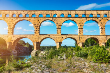 Fototapeta premium Exploring the majestic Pont du Gard aqueduct in France, discover the stunning architecture of the ancient Pont du Gard aqueduct in southern France. River Gard, Languedoc-Roussillon, France.